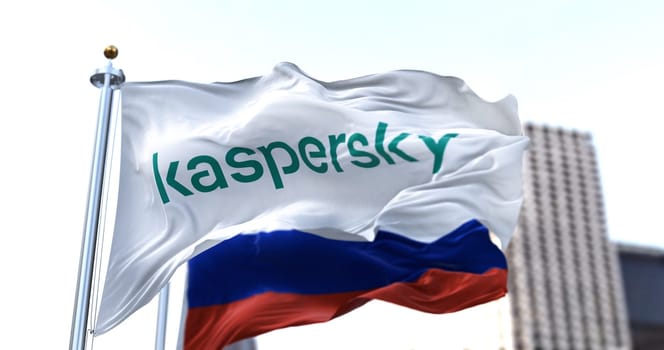 Moscow, RUS, March 2022: white flag with the logo of Kaspersky Lab waving in the wind with the Russian flag blurred in the background. Kaspersky is a Russian computer security software company