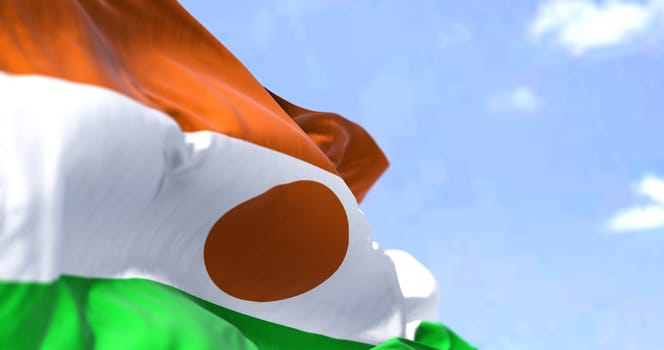 Detail of the national flag of Niger waving in the wind on a clear day. Niger is a landlocked country in West Africa. Selective focus.