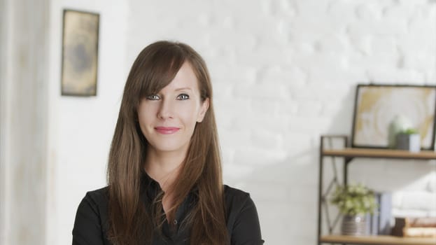 Portrait of confident woman at home, smiling in front of casual home indoor.