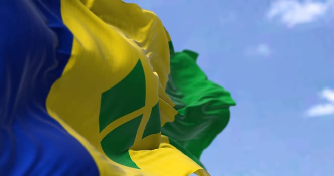 Detail of the national flag of Saint Vincent and the Grenadines waving in the wind on a clear day. Saint Vincent and the Grenadines is an island country in the Caribbean. Selective focus.