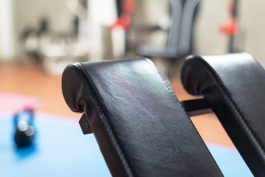 Black desk of free space for your decoration and blurred gym interior.Metal dumbbells and fit life
