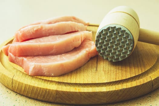 Slices of pork on a cutting board, Meat mallet