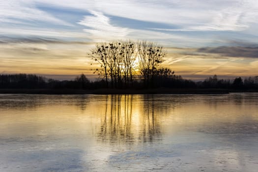 Sunset over the frozen lake and trees, Stankow, Poland