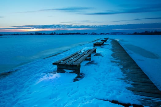 Wooden pier with benches and a snow-covered lake, Zoltance, Poland
