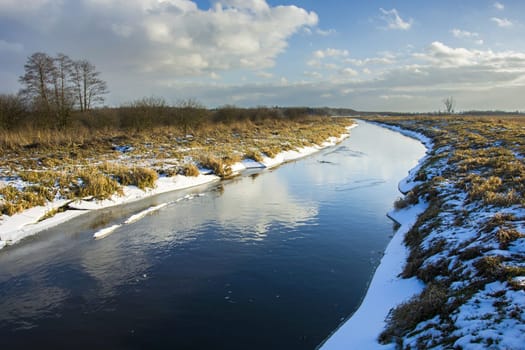 Uherka river, snow and clouds on the sky, Czulczyce, Poland