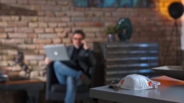 Covid-19 virus danger - Businessman working at safety of home office leaving virus protective mask on desk.