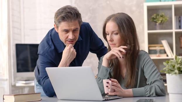 Business people working in office with laptop computer. Couple working from home at desk. Talking, meeting, cooperation, entrepreneurs, advisor.