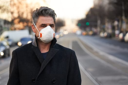 Coronavirus disease - man wearing face mask on city street to protect herself from the covid-19 virus.