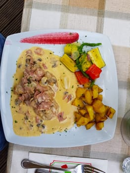Fried potatoes and schnitzel with sauce