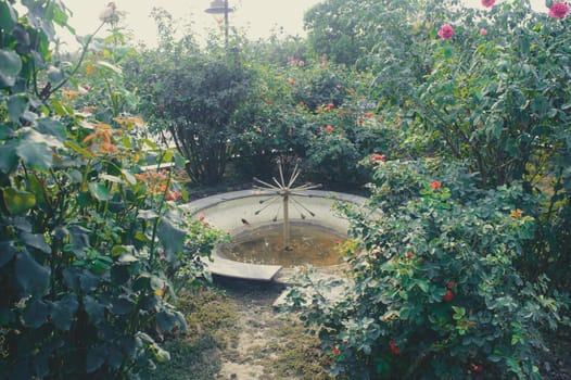 Beautiful Garden Water Fountain in the Yard Ground on a Public Park surrounded by flowers.