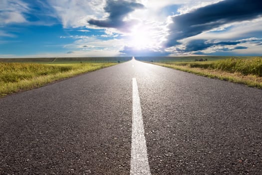 Driving on an empty road to the sun