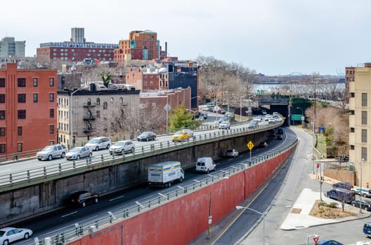 Lots of car traffic on the street crossing on different levels entering and exiting Brooklyn Bridge, Manhattan, New York City, during daytime, horizontal