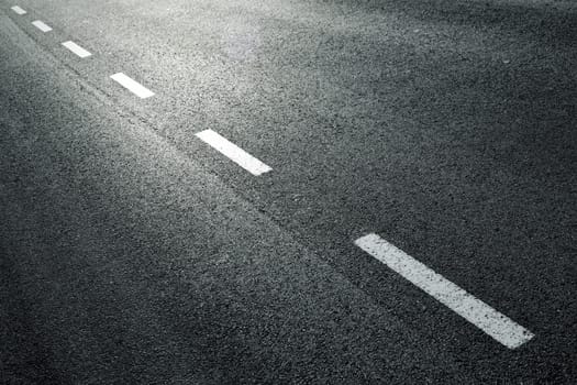 White dotted line on city asphalt road background.