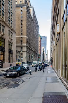 Manhattan, New York City, Side Street with Cars and People walking on Sidewalk, delivery vehicle in the background, puddle in the forefront, vertical