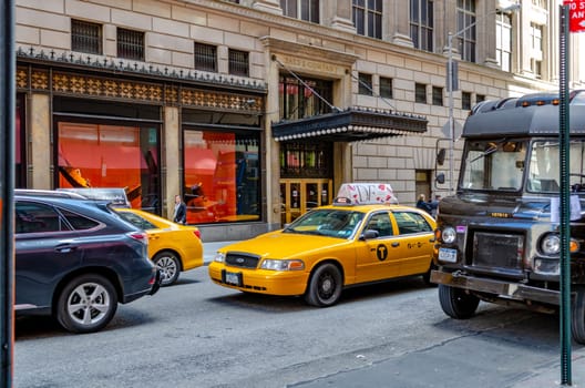 Traffic Jam in Manhattan, New York City, Yellow Taxi Cabs and delivery vehicle standing close to each other in a narrow street, Saks & Company in the background, horizontal