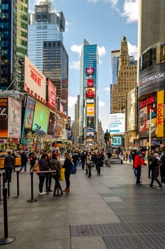 Crowded Time Square New York City with lots of People standing and walking around in the evening, Skyscraper with advertisement on it, vertical