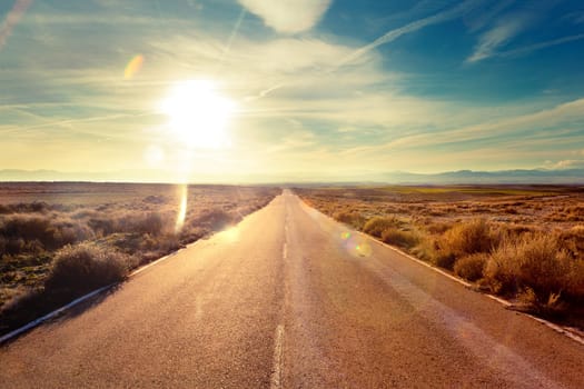 Road through landscape. Road and car travel scenic and sunset.
