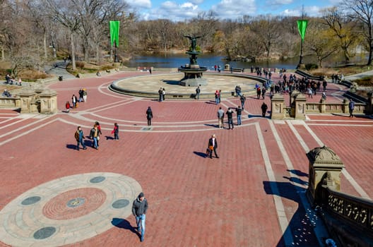Bethesda Fountain with Angel of the Waters Sculpture wide angle shot, aerial view Central Park New York, lots of people around the fountain, lake in the background during daylight in winter, horizontal