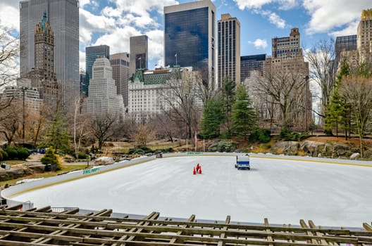 Wollman Rink during winter with no people on the ice as it gets renewed, skyline of Manhattan, great weather during daytime, New York City, horizontal