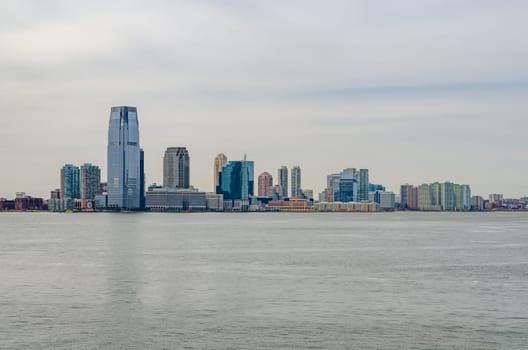 Jersey City Skyline wit lots of skyscraper office Buildings, New Jersey with Hudson river in forefront, during winter day and overcast, horizontal