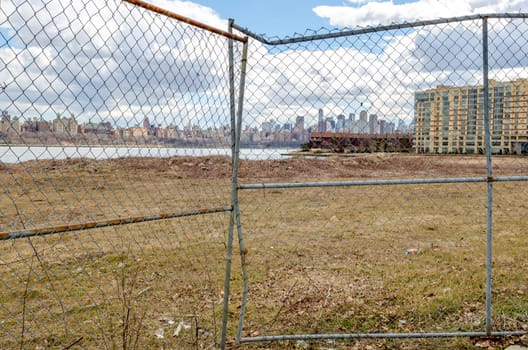 View of Manhattan with Hudson river, Construction area fence in the forefront, view from North Bergen, New Jersey, during a sunny winter day, horizontal