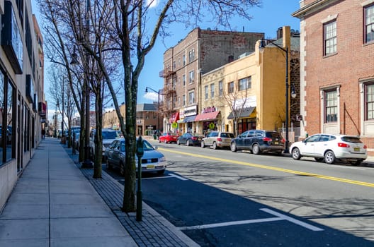 Retail Stores at Center of the City near Cliffside Park, New Jersey, during a sunny winter day, Cars are parked in the street, two free parking lot in front, horizontal