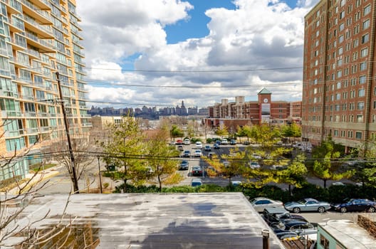 Residential skyscraper Buildings and parking lot at Cliffside Park with view of Harlem at the horizon, New Jersey, during a sunny winter day, horizontal