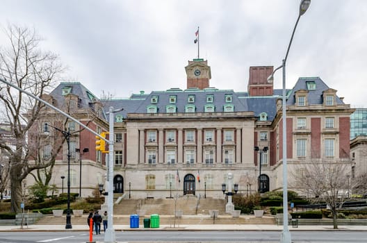Staten Island Borough Hall with traffic lights and people crossing the street in the forefront, New York City, during winter day with overcast, horizontal