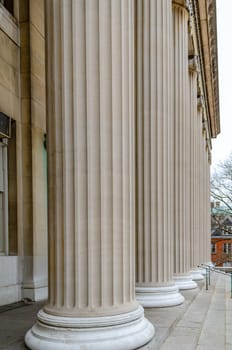 Columns in a row of The Library of Columbia University, close-up, New York City, during winter day with overcast, vertical