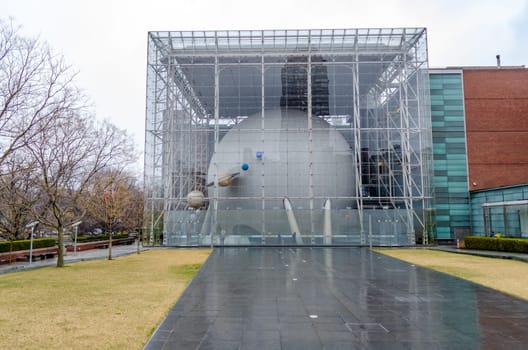The Hayden Planetarium Building at New York City during rainy winter day with overcast, different Planets, horizontal