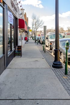 Retail Stores at Center of the City near Cliffside Park, New Jersey, during a sunny winter day, lots of cars parked next to the street, vertical