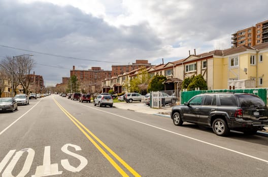 Residential Area in Queens, City street with parked cars and lots of different houses, New York City during  overcast winter day, horizontal