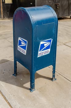 Blue United States Postal Service Mailbox standing on a sidewalk in Manhattan, New York City, daylight, vertical