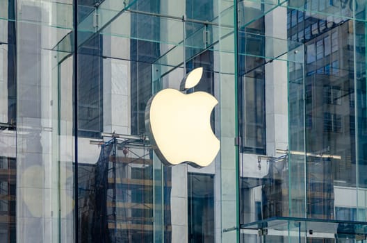 Close-up of the Apple Logo at the Apple Store in Manhattan, White apple behind glass cube, New York City during sunny winter day, horizontal