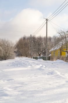 Snow-covered village streets in winter in Belarus. Frosty morning. Vertical image