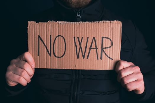 Man holding placard No war text. Freedom to Ukraine concept.