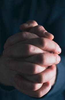 Praying hands with faith in religion and belief in God on dark background. Power of hope or love and devotion.