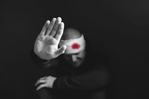 Wounded man showing stop gesture. Stop war, russian aggression, freedom to Ukraine concept.