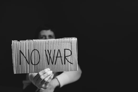 Sad woman calls to Stop war in Ukraine, raises banner with inscription No war.