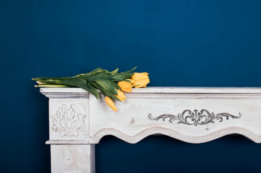Tulip bouquet on vintage fireplace and blue wall