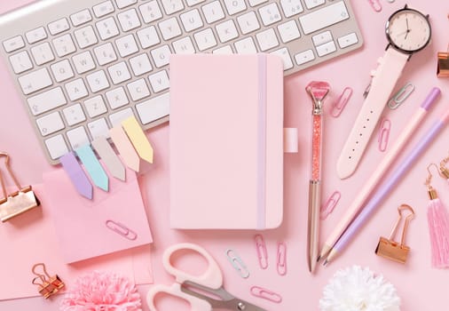Hardcover notebook, Pink school accessories and keyboard on light pink, Top view, textbook mockup. Girly workplace with notebook, scissors, pencil, pen, paperclips, cards and watch. Back to school