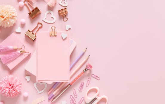 Paper with a clip, Pink school accessories and hearts on light pink, Top view, mockup. Girly workplace with notebook, scissors, pencil, pen, paperclips, cards and watch. Back to school