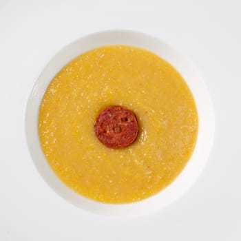 Polenta with butter and parmesan cheese and chorizo sausage in a plate