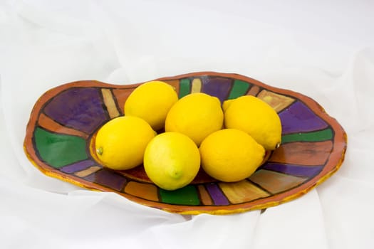fresh lemons on a clay plate - handmade pottery