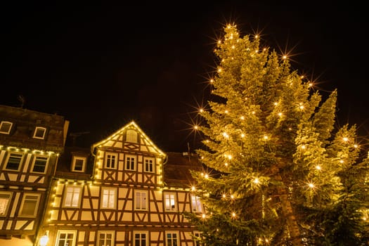 Christmas tree with lights and half-timbered house Schorndorf Germany