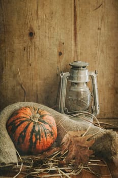 Still life. Pumpkin, lantern and autumn leaves.