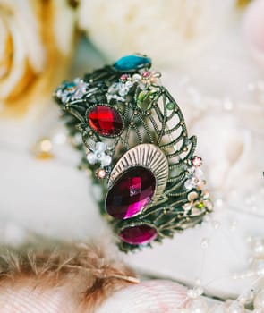 Luxury bracelet and female accessories on white wooden table