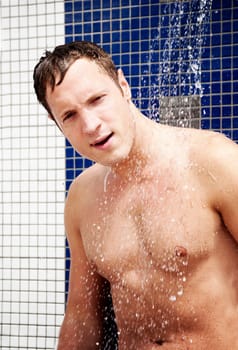 Portrait of handsome blond man under an outdoor shower