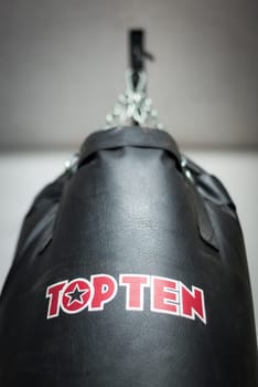 boxing sacks hanging inside a gymnasium with daylight in the background