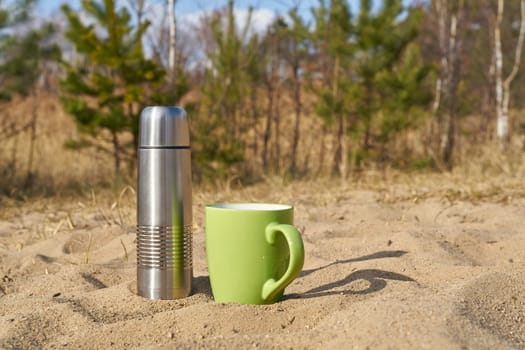 Picnic with thermos and cup on a spring day in nature